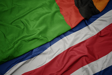 waving colorful flag of costa rica and national flag of zambia.