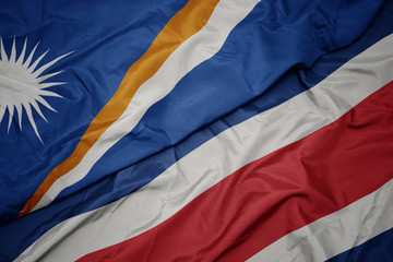 waving colorful flag of costa rica and national flag of Marshall Islands .