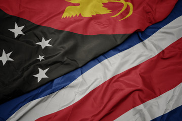 waving colorful flag of costa rica and national flag of Papua New Guinea .