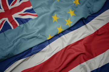 waving colorful flag of costa rica and national flag of Tuvalu .