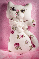 Self made soft toy. Handmade  cat. Manual sewing  white with pink flowers  toy cat. A fun, soft toy made with your own hands.