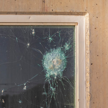 Square Bullet holes in the window glass of a bulletproof bunker