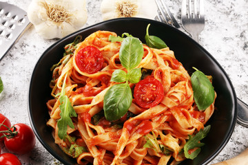tagliatelle pasta with tomato sauce parmesan basil on rustic background