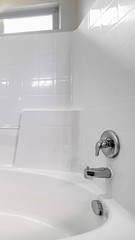 Vertical Fitted white oval bath in a compact bathroom