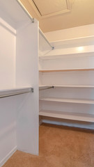 Fototapeta na wymiar Vertical frame A white walk in closet with empty shelves