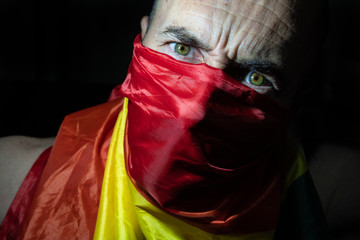 man with aggressive expression with a flag of spain covering his face