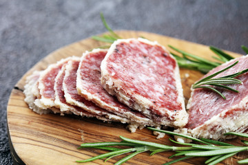 Salami truffle. The saltufo is a piece of salami mixed with summer truffle on rustic background