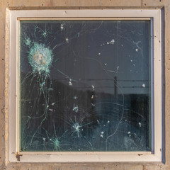 Square frame Bullet holes in the window glass of a bulletproof bunker