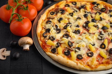Pizza with ingredients, tomatoes, salami, mushrooms, mazzarella sauce and cheese and pizza knife. Italian pizza, culinary recipes concept, menu, restaurant, gourmet cuisine.