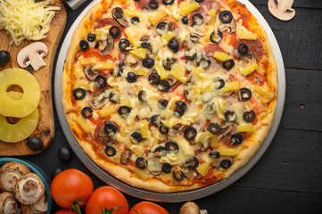 Pizza with ingredients, tomatoes, salami, mushrooms, mazzarella sauce and cheese and pizza knife. Italian pizza, culinary recipes concept, menu, restaurant, gourmet cuisine.