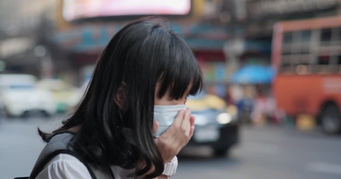 Little girl wearing mask and cough at the road. Health care and medical concept.