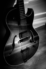 Fototapeta na wymiar Black jazz archtop guitar with holes. hollow steel-stringed acoustic or semiacoustic