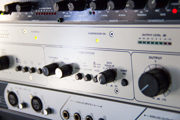 A rack of audio compressors in a recording studio.