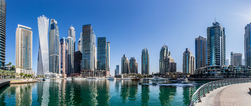 Dubai Marina skyline during the day of buildings and water with boats