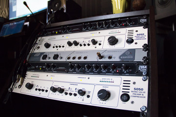 A rack of audio compressors in a recording studio.