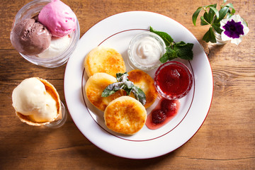 Homemade cottage cheese pancakes. Syrniki (popular dish in Russia and Ukraine) with fresh mint, sour cream and strawberry jam, ice cream - dessert concept