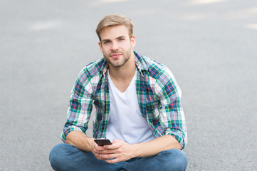 wait for call. street style. man sit on ground. carefree student. free time spending. summer...