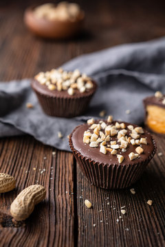 Cold crunchy treat, chocolate cups with caramel and peanut butter filling, sprinkled with chopped nuts