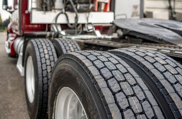 Naklejka na ściany i meble Wheels with tires on axels of big rig semi truck standing on parking lot