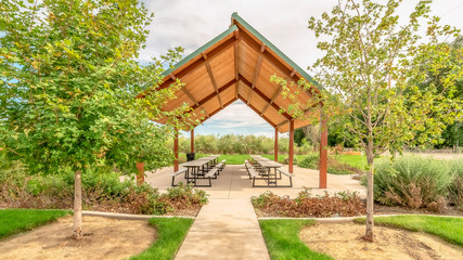 Panorama frame Beautiful view of a picnic pavilion at a park with pathway and trees in front