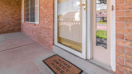 Panorama frame Front door of suburban brick home with welcome mat