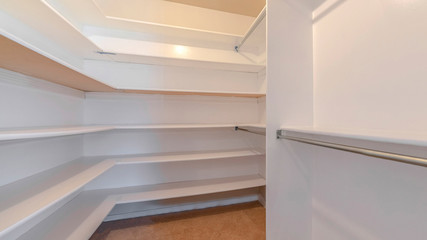 Panorama A white walk in closet with empty shelves