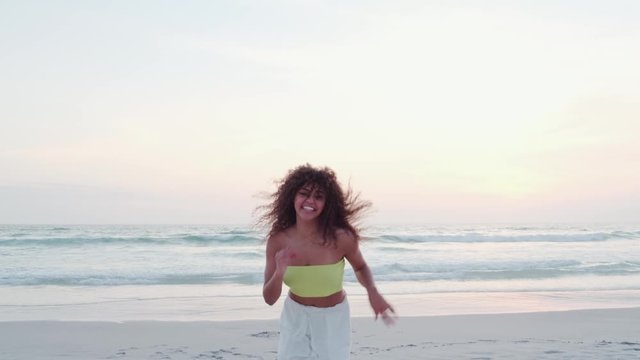 Black beautiful attractive afro young cute girl, curly hair, bikini, famous beach Rio de Janeiro, Brazil. Latin summer vacation holiday. Cinematic 4K.