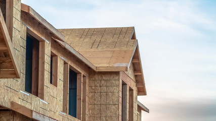Fototapeta premium Panorama Close up of the exterior of townhomes under construction against cloudy sky
