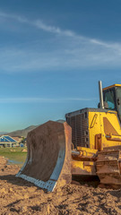 Fototapeta premium Vertical frame Bulldozer at a construction site with copy space