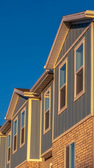 Fototapeta na wymiar Vertical frame Townhomes on a neighborhood with vibrant blue sky background on a sunny day