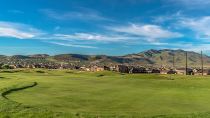 Obraz premium Panorama Golf course and houses with view of mountain towering in the distance