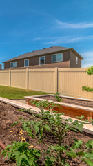 Vertical Close up of growbeds at the sunny backyard of a home with gravel and grasses
