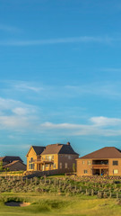 Obraz premium Vertical Sand trap and fairway at a golf course with multi storey homes in the background