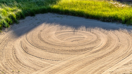 Panorama Close up of a sand trap surrounded by grasses at a golf course on a sunny day