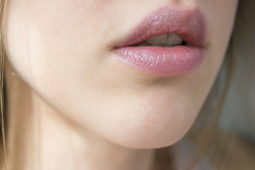 Obraz premium Young beautiful woman's lips view Nude lipstick/balm, lip care.Healthy skin, beauty concept