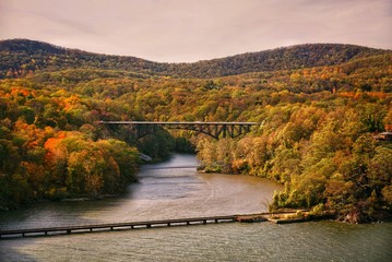 Fototapeta na wymiar Landscape view of a bridge and mountains in early fall during the sunset at Bear Mountain State Park