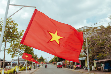 Vietnam flag flies in the wind on a city street