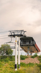 Vertical frame Focus on chairlifts over mountain of Park City Utah against cloudy sky in summer