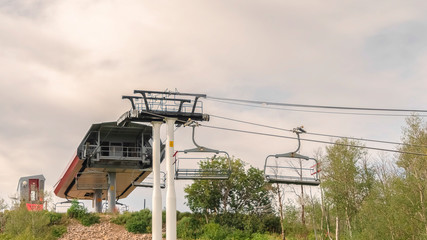 Panorama Focus on chairlifts over mountain of Park City Utah against cloudy sky in summer
