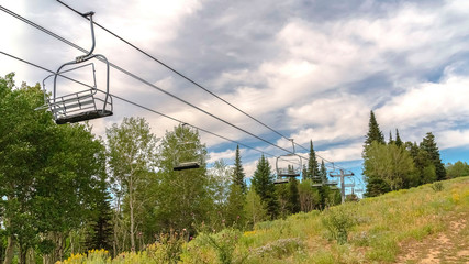 Fototapeta premium Panorama Chairlifts in Park City with a scenic aerial view of greenery during off season