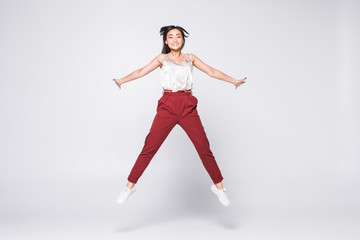 Happy asian woman jumping for joy isolated on a white background.