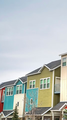 Vertical frame Townhouses with colorful exterior walls with cloudy sky background in winter