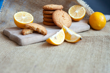 lemon gingerbread cookies lie on a wooden board on a rustic table, still life of fresh biscuits with citrus, copy space