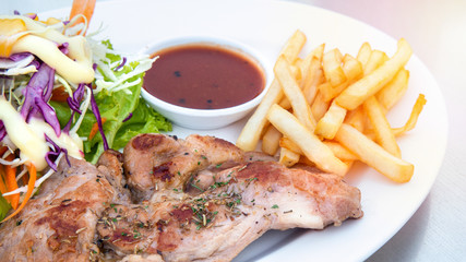 Pork steak with french fries on a white dish