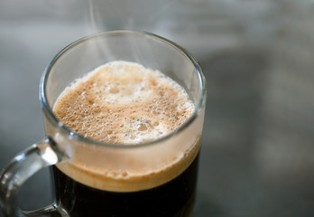 Espresso coffee in a glass mug. Isolated dark background.