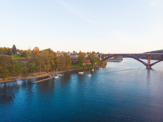 Obraz premium Autumn sunset with a bridge over the river, landscape shot from a height
