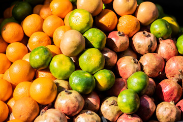 tangerines pomegranate and orange heap close-up. On the light of day.