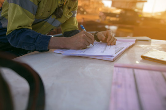 Construction supervisor holding a pen signing issuing safety permit to work on the opening field prior to performing working at height of each task   