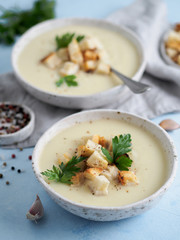 cauliflower potato soup puree on blue tabletop, Creamy cauliflower soup with toasted bread...