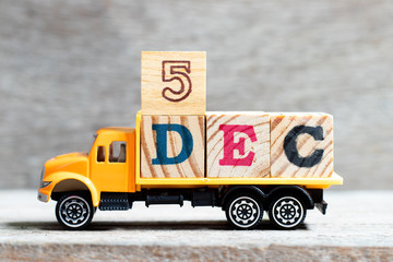 Truck hold letter block in word 5dec on wood background (Concept for date 5 month December)
